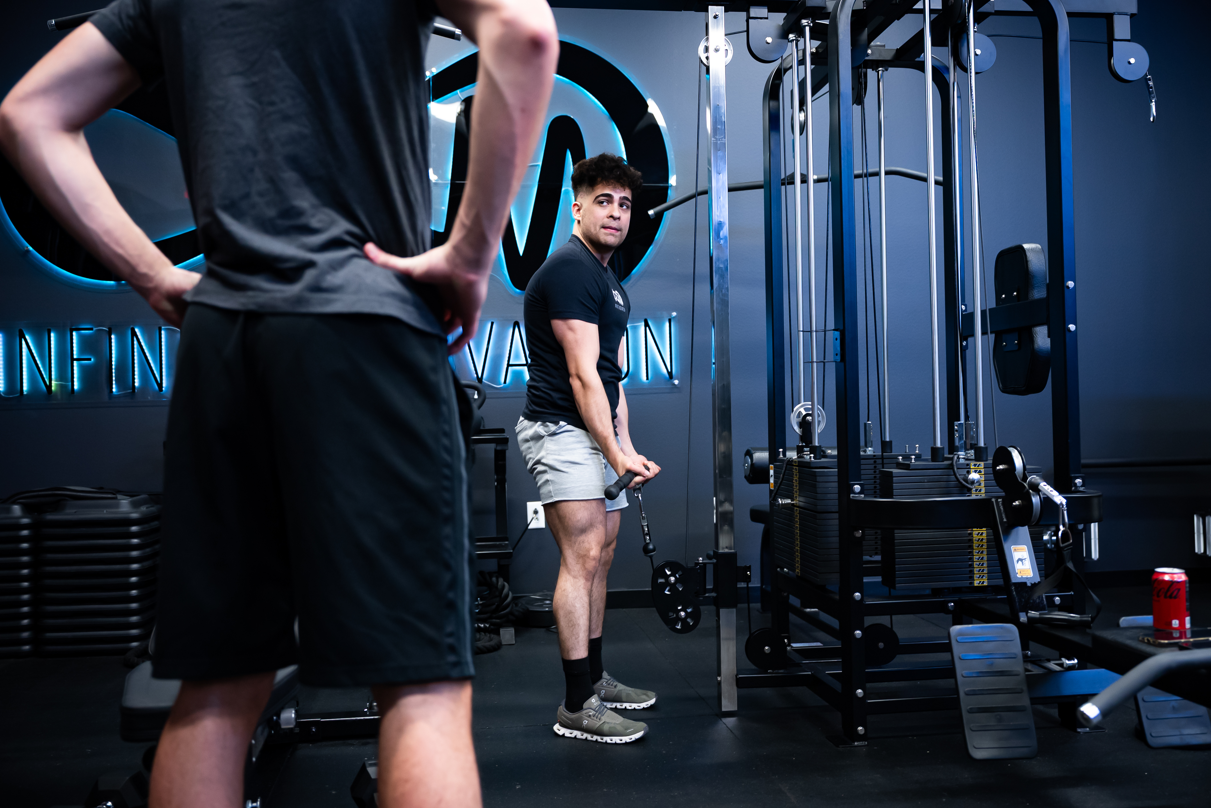 Trainer providing personal bicep curl instruction to client